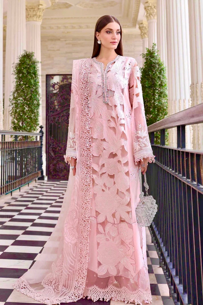 Model in light pink embroidered chiffon suit paired with a matching embroidered border dupatta and holding a embellished silver clutch.