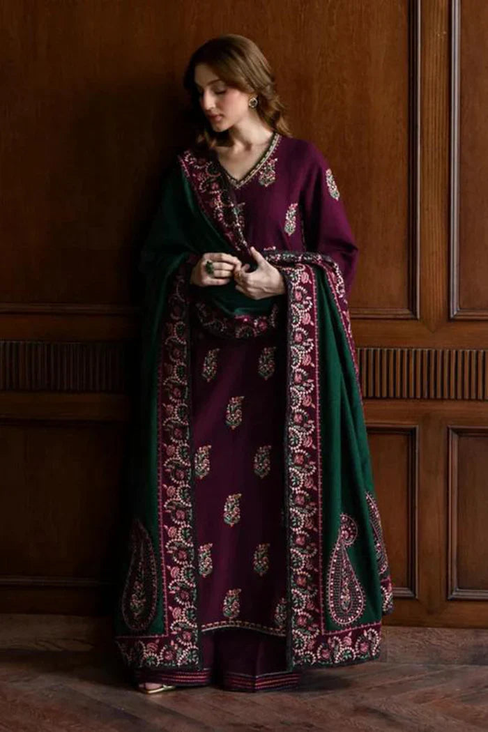 Model posed against a dark wood-paneled wall wearing a deep purple Batik Cotton Dress featuring pure lawn front with heavy sequence, resham, and thread embroidery, paired with a green ready-to-wear chiffon embroidered dupatta and plain dyed trouser by pakiclothing.
