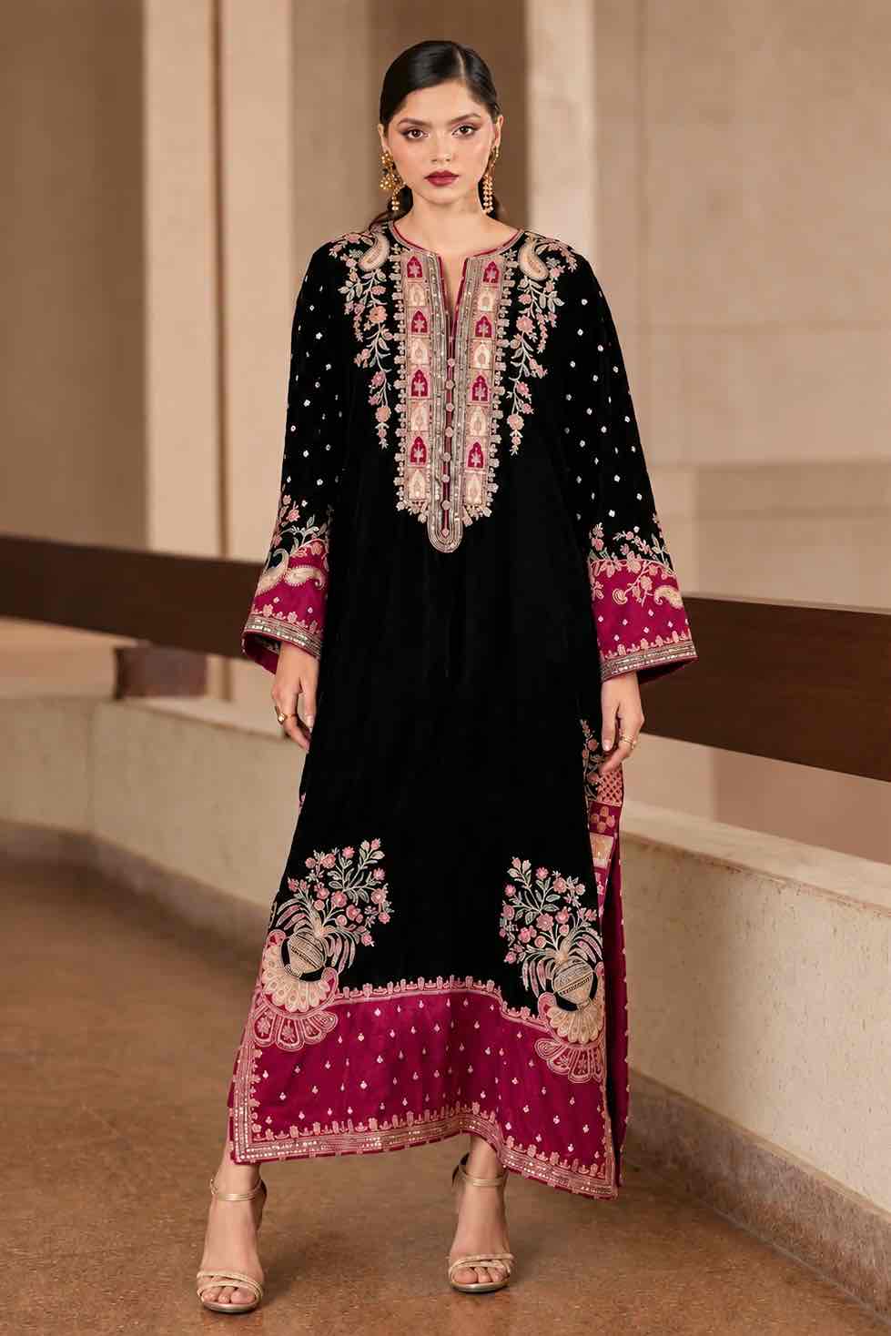 Model wearing a stitched black Shamoze silk kaftan suit featuring heavy floral neckline embroidery and maroon embellished hem.