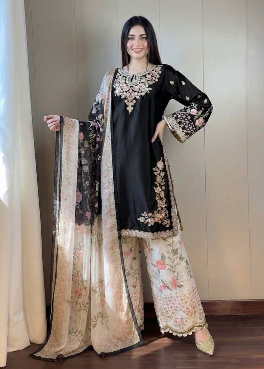 Full-length standing pose of model in ethnic black luxury silk shirt with embroidered neck, side slits, floral trousers, and matching digital printed silk dupatta - Shop Now