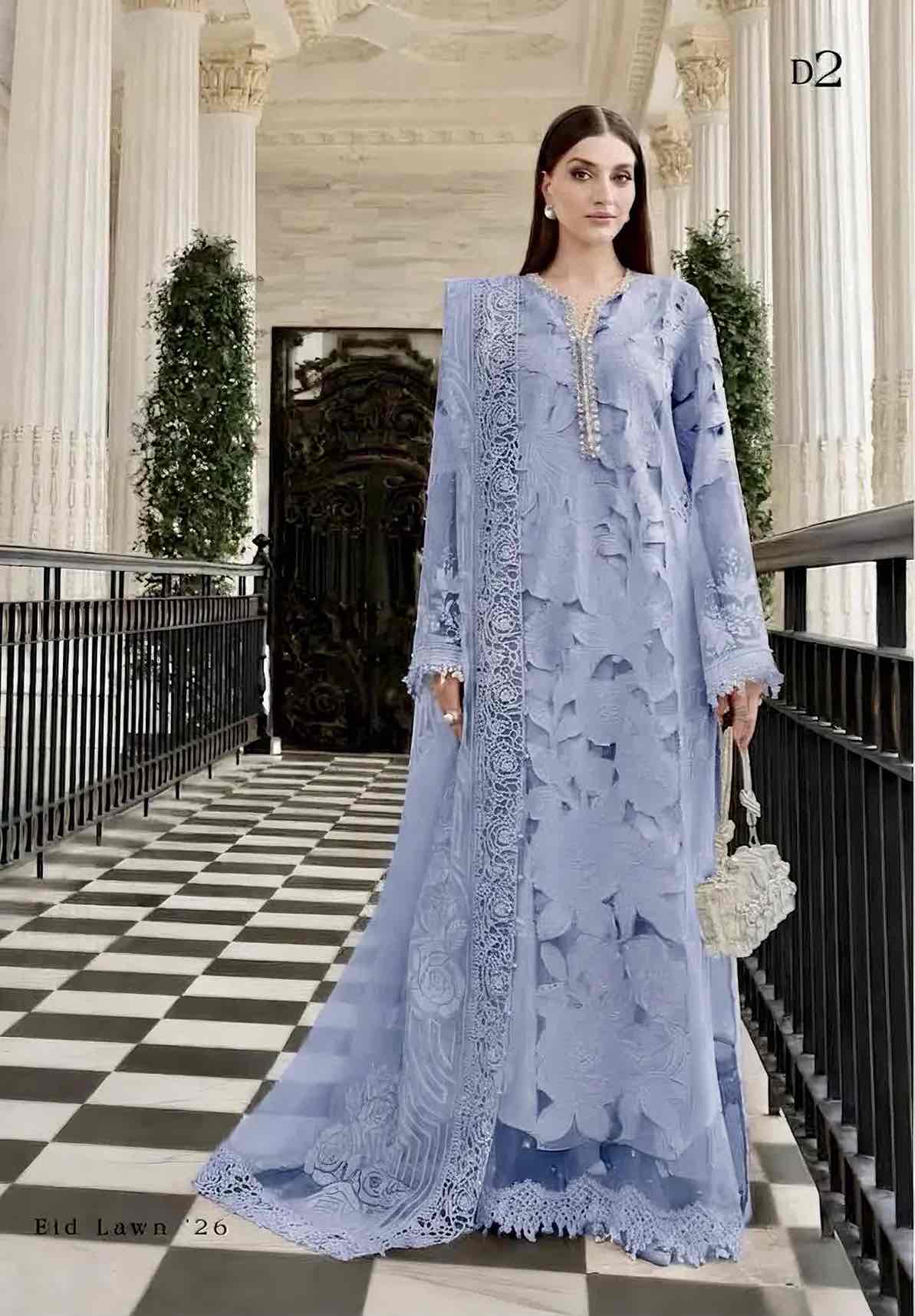 A woman models a light blue embroidered traditional outfit with a matching sheer overlay in an elegant indoor corridor with a black-and-white checkered floor.