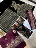 Embroidered fabric samples with gold and purple patterns on a magazine