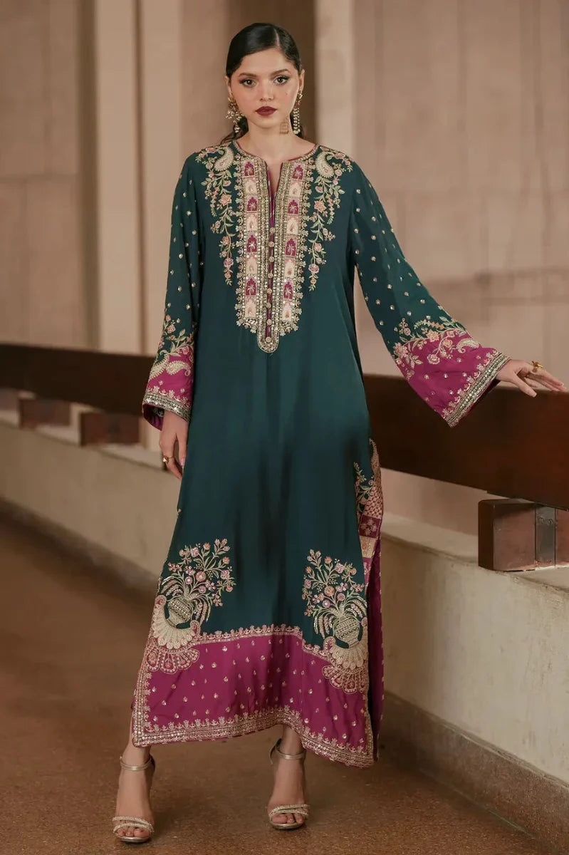 Front view of a model in an emerald green shamooz silk kaftan featuring heavy embroidered spengle neck and daman work. Buy now at PakiClothing!