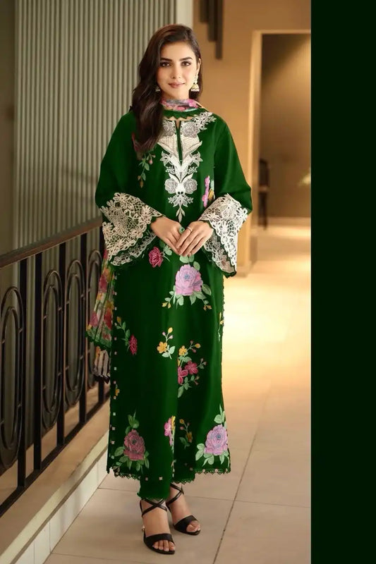 Woman wearing a green embroidered dress with floral patterns indoors.