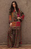 A woman models a traditional South Asian outfit consisting of a patchwork embroidered kurta in olive brown with pink, red, and green floral details, paired with matching wide-leg trousers and a coordinating embroidered dupatta, set against a textured brown wall.
