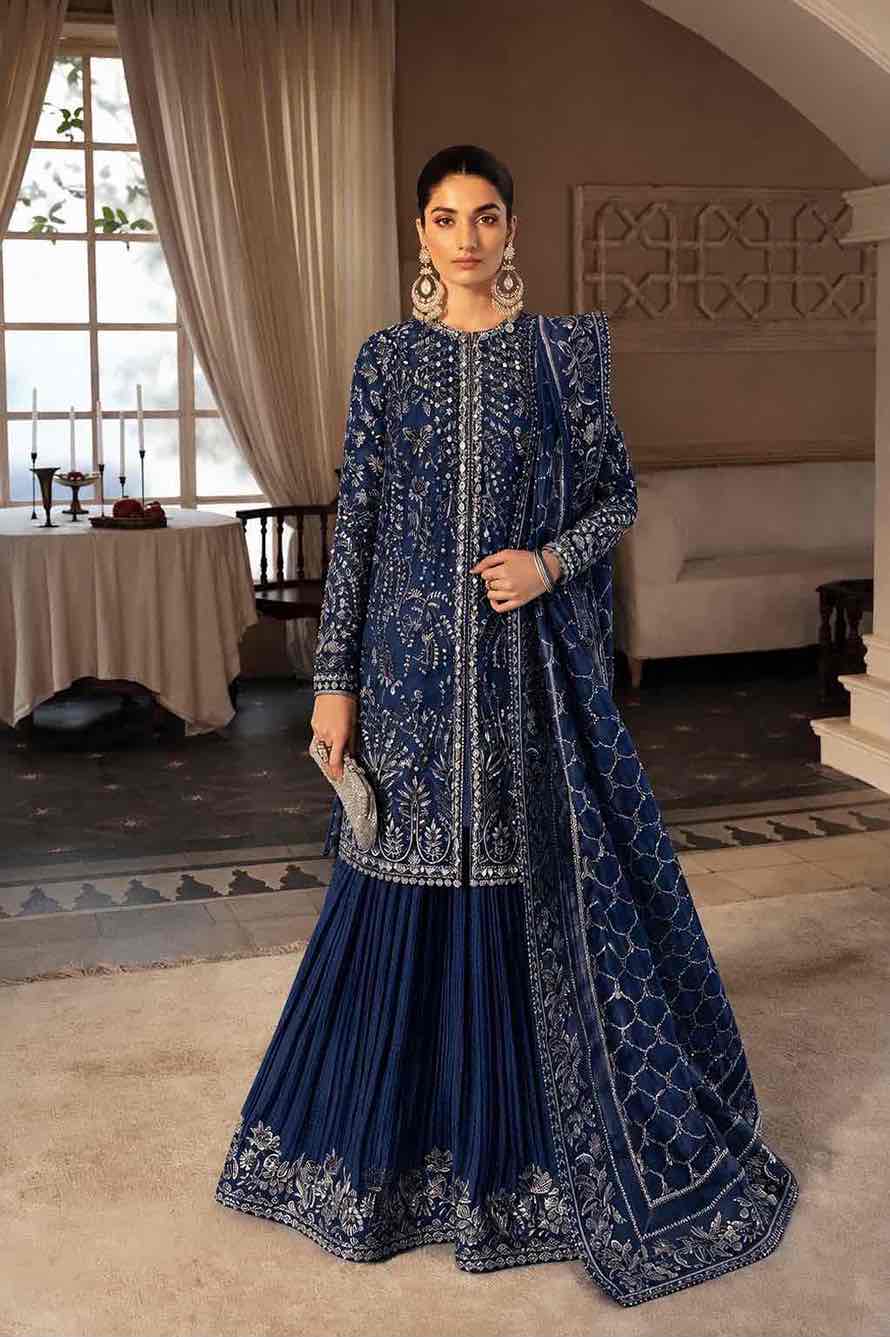 Full-length front view of a model showcasing the complete navy blue Soraya ensemble featuring silver floral handwork, a pleated Soraya crush silk gharara with embroidered hem patches, and a matching dupatta.