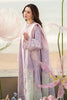 Woman in a light purple embroidered outfit with floral background side pose